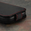 Magnetic closing clasp on the Black with Red Detail Leather Flip Case for iPhone 15 Pro