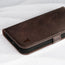 Close up of the leather texture and TORRO bull's head logo on the Dark Brown Leather Folio Stand Case for iPhone 14 Plus
