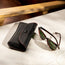 Sunglasses next to the Black with Red Stitching Leather Sunglasses Case