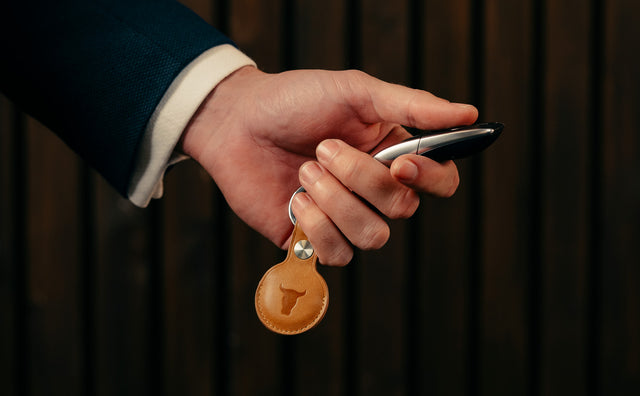 Han holding the Tan Leather AirTag Holder Keyring (attached to a car key)