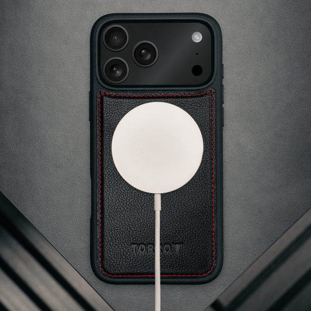MagSafe charger attached to the Black with Red Detail Leather Detachable Case for iPhone 17 Pro Max