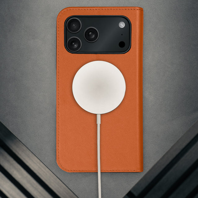 MagSafe charger attached to the Orange Leather Case for iPhone 17 Pro Max
