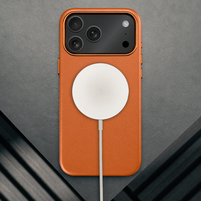 MagSafe charger attached to the Slimline Orange Leather Bumper Case for iPhone 17 Pro