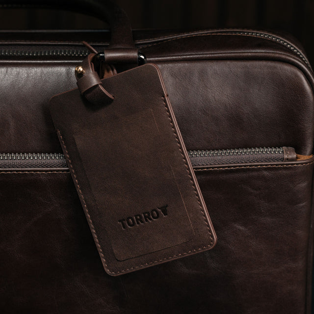 Dark Brown Leather Luggage Tag attached to luggage