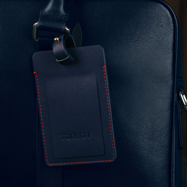 Navy Blue Leather Luggage Tag attached to luggage