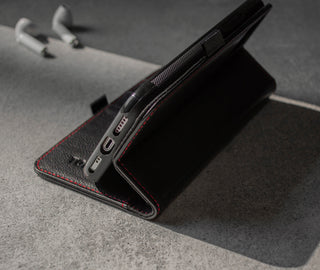 Demonstrating the integrated stand function of the Black Leather (with Red Stitching) Stand Case for iPhone 11 Pro Max