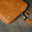 Tan Leather Messenger Bag on a wooden table