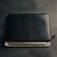 Large All Black Leather Laptop Sleeve with laptop and protective flap
