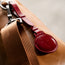 Red Leather AirTag Holder / Bag Loop attached to Tan leather bag