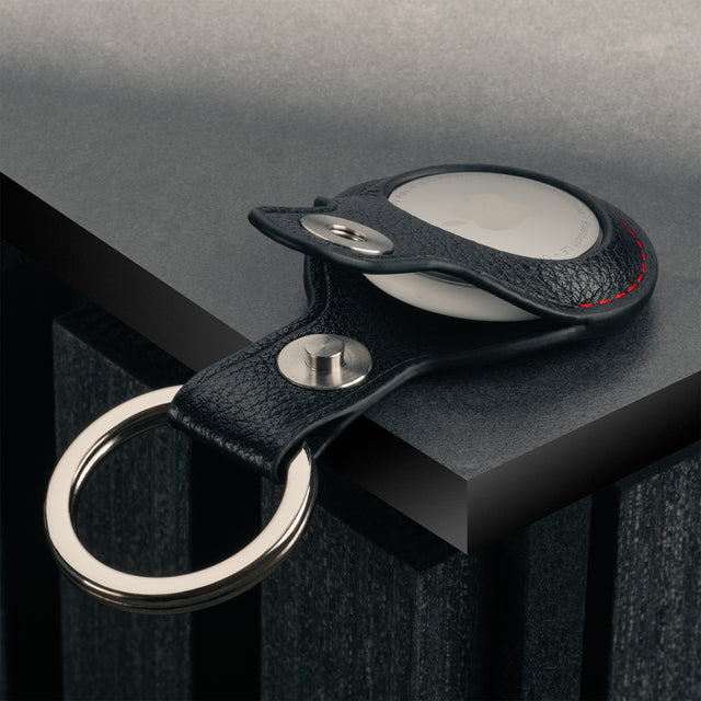 Close up of the press stud clasp on the Black with Red Detail Leather Apple AirTag Holder Keyring