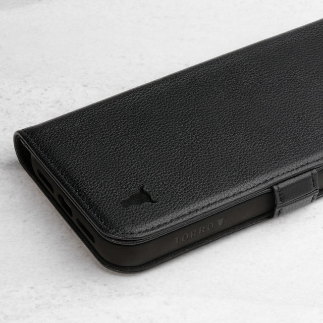 Close up of the leather texture and TORRO bull's head logo on the Black Leather Folio Stand Case for iPhone 14