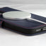 MagSafe charger attached to the Navy Blue Leather Folio Case (MagSafe) for iPhone 14 Pro