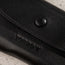 Close up of the pop button closure on the Black Leather Sunglasses Case