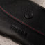 Close up of the TORRO logo and pop button closure on the Black with Red Stitching Leather Sunglasses Case