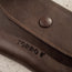Close up of the pop button close on the Dark Brown Leather Sunglasses Case